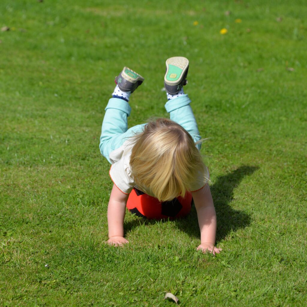 a little girl balancing on a football 2023 11 27 05 16 22 utc