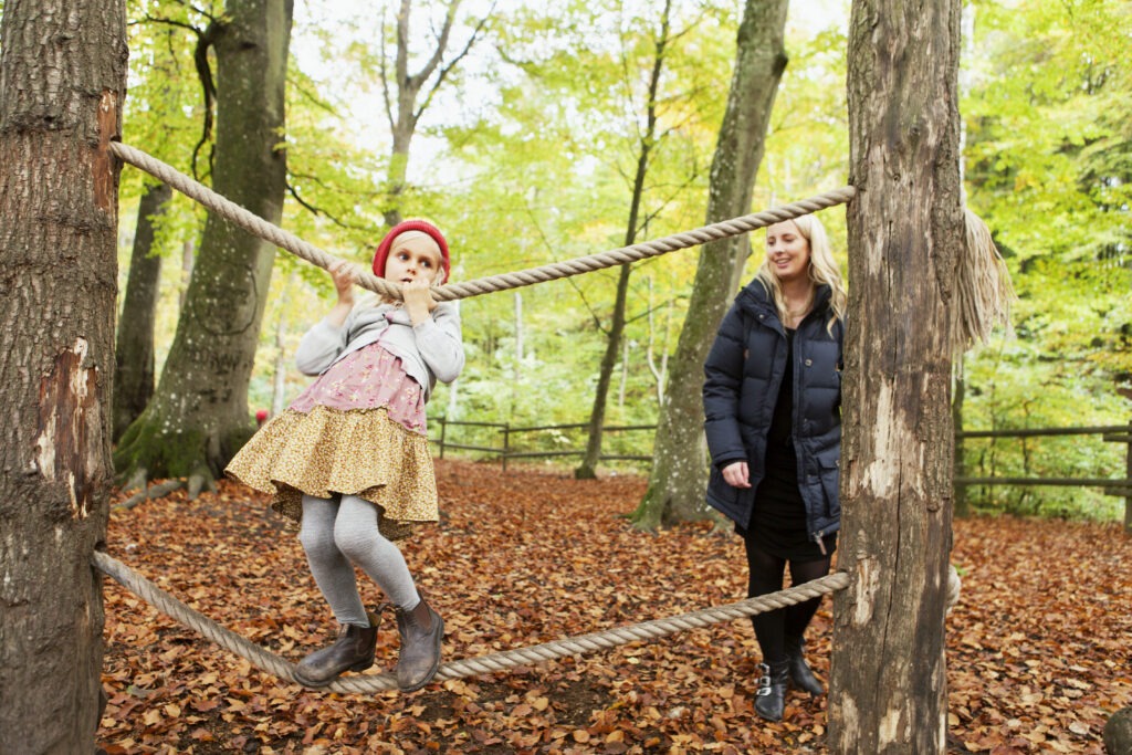 mother looking at girl balancing on rope in forest 2023 11 27 04 53 19 utc